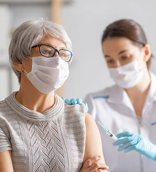 Doctor,Giving,A,Senior,Woman,A,Vaccination.,Virus,Protection.,Covid-2019.