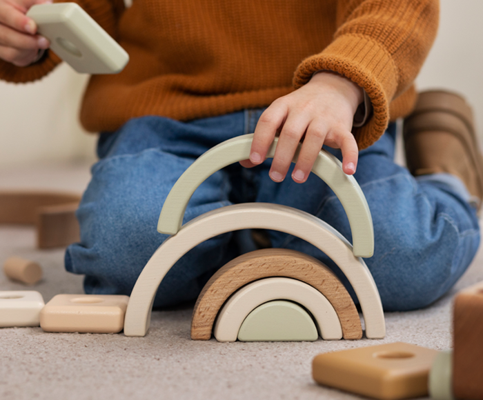 Manos de un niño jugando con juguetes de madera