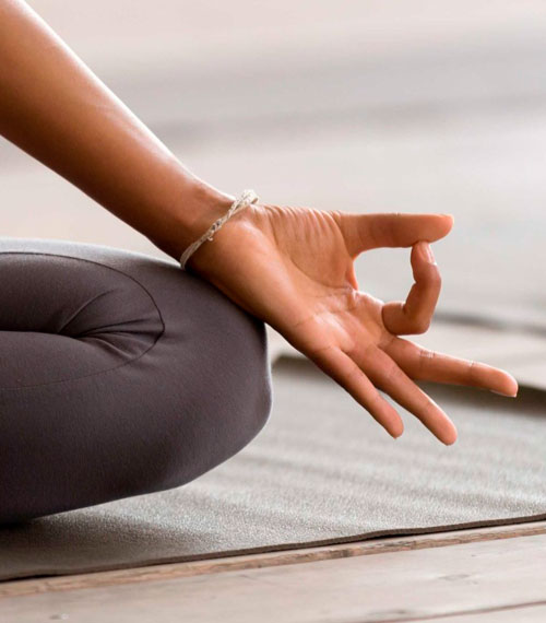 Mujer de piernas cruzadas haciendo yoga