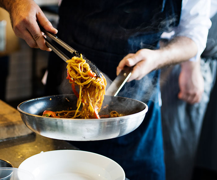 Cocinero saltando spaguettis