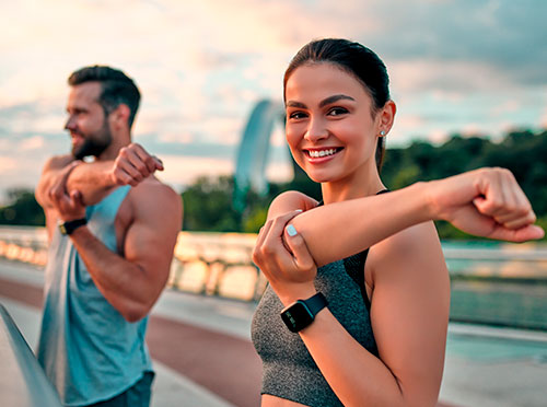 Hombre y Mujer realizando estiramiento al aire libre