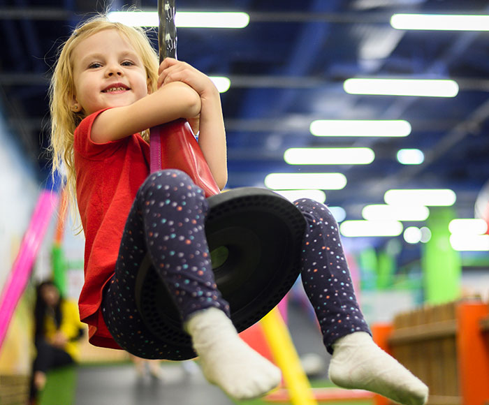 Niña jugando en salón de juegos infantiles