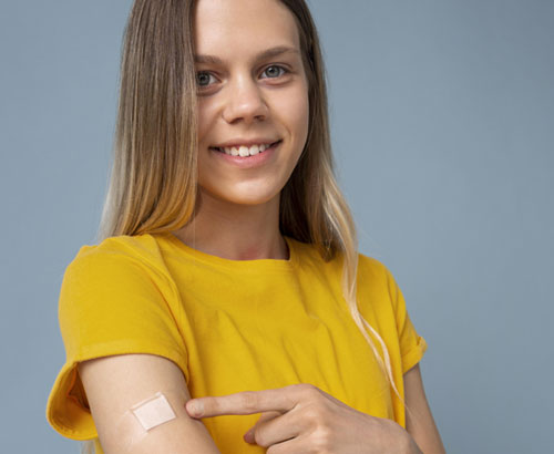 Adolescente mostrando una curita en su brazo luego de una vacuna