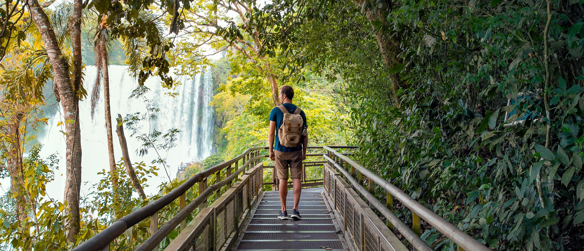 Hombre caminando en un parque con una cascada de fondo | Persona manejando con el celular en la mano | Movilidad Humana, Responsabilidad Humana Hombre caminando en un parque con una cascada de fondo | Persona manejando con el celular en la mano | Movilidad Humana, Responsabilidad Humana