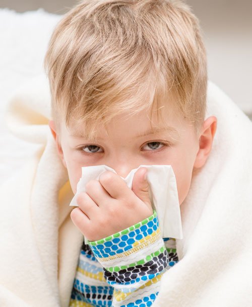 Niño sonándose la nariz | Resfriados en niños: claves para prevenirlos