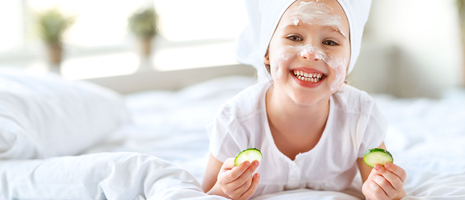 Niña con crema en la cara y dos rodajas de pepino en sus manos | Piel joven, presión adulta: el auge del skincare infantil Niña con crema en la cara y dos rodajas de pepino en sus manos | Piel joven, presión adulta: el auge del skincare infantil