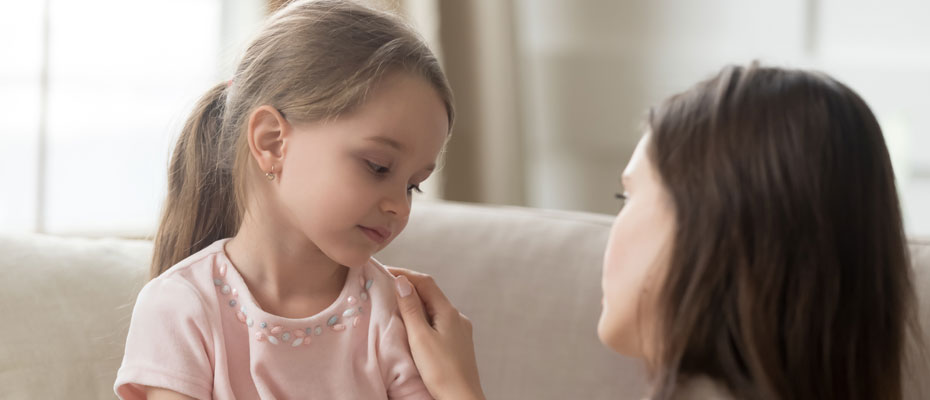 Mujer hablando con una niña que se ve triste | Cómo proteger la salud mental de niños y adolescentes en el mundo actual