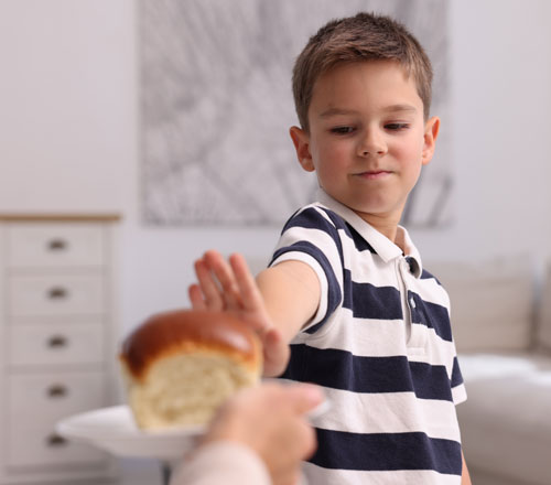 Niño rechazando un trozo de pan | Enfermedad Celíaca: desafíos y novedades en 2025 Niño rechazando un trozo de pan | Enfermedad Celíaca: desafíos y novedades en 2025