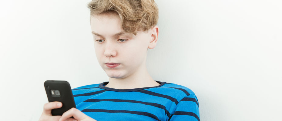 Adolescente mirando un celular | Pornografía en niños, niñas y adolescentes 
