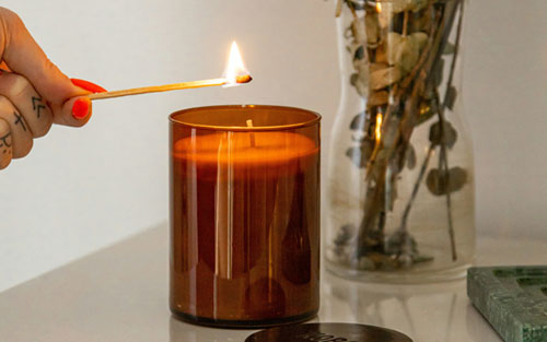 Mano de una mujer encendiendo una vela | Cuando el duelo atraviesa las fiestas