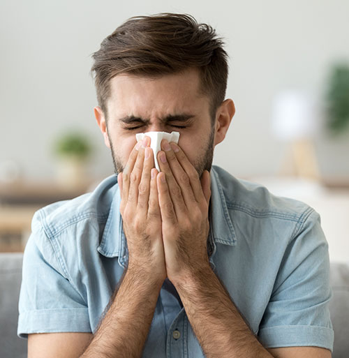 Hombre resfriado con un pañuelo en la nariz | Influenza H3N2: qué es, por qué es más contagiosa y cómo prevenirla