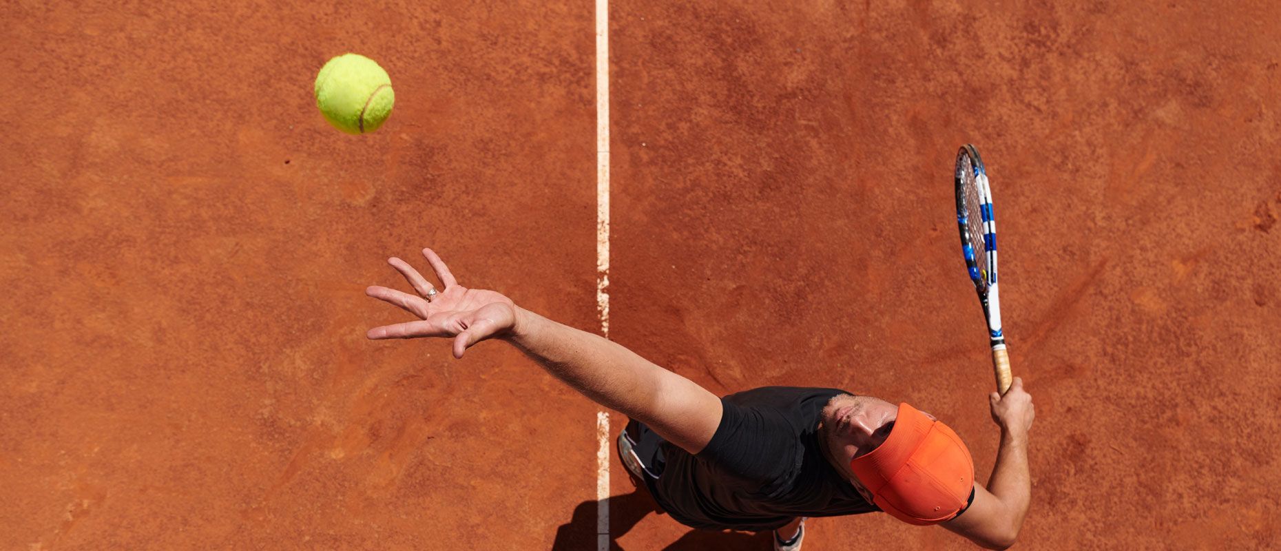 Imagen cenital de un hombre jugando el tenis | El tenis como aliado del bienestar
