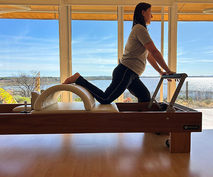 Mujer realizando pilates con aparatos | Movimientos Pilates