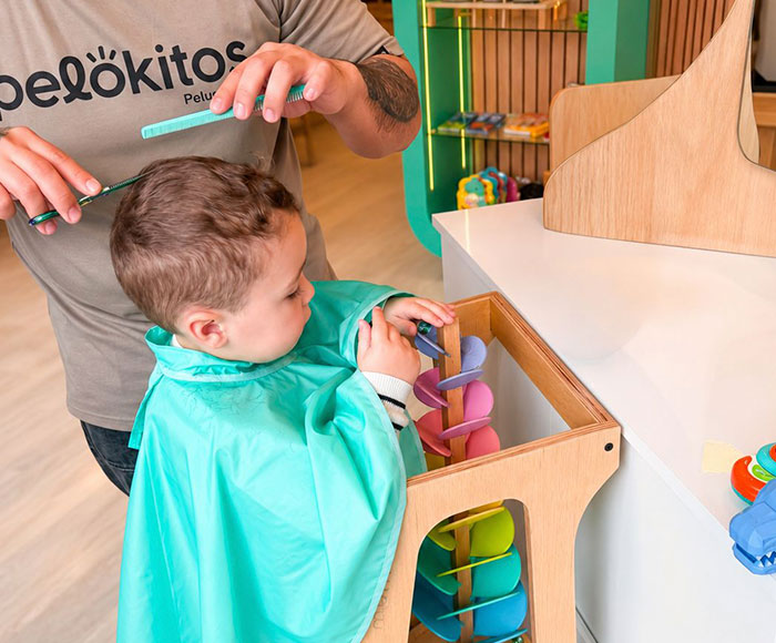 Peluquero de Pelokitos cortando el pelo a un niños | Pelokitos - Beneficio MP