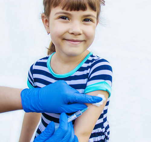 Niña recibiendo una vacuna | Meningitis: qué es, cómo se transmite y cómo prevenirla
