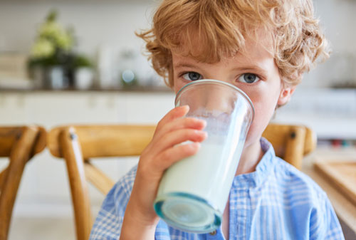 Niño tomando un vaso de leche | Cuidar nuestros huesos: una inversión para toda la vida