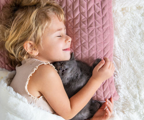 Niña durmiendo con un cachorro de gato | Tu mascota y tu salud van de la mano