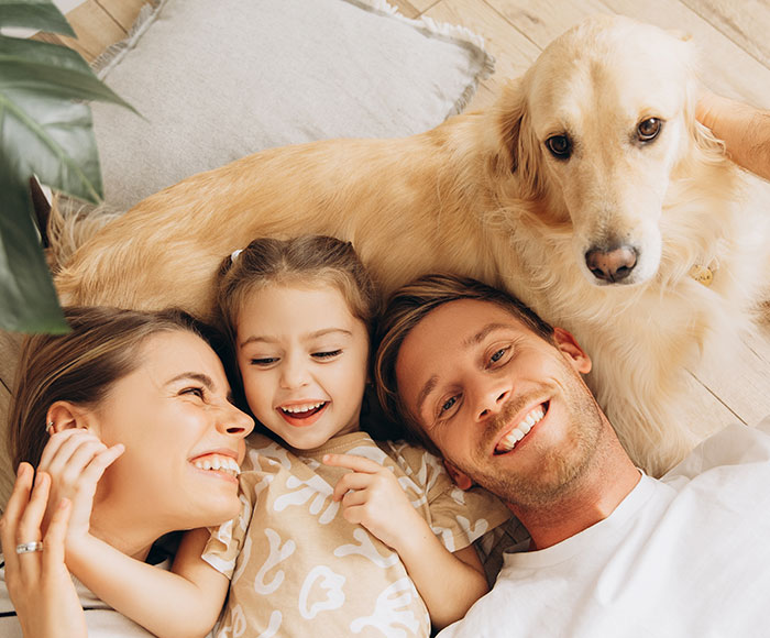 Familia con un perro acostados en el piso | Beneficios MP
